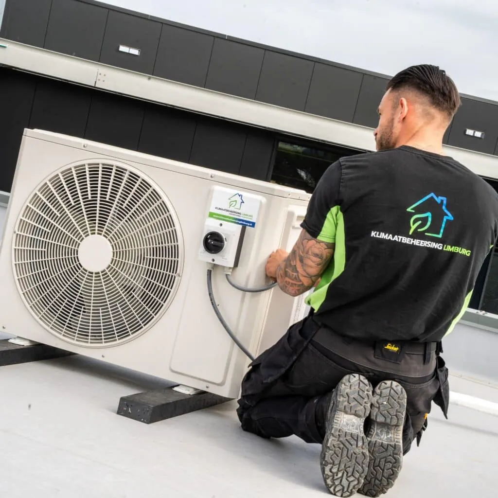 Monteur van Klimaatbeheersing Limburg voert onderhoud uit aan een airco
